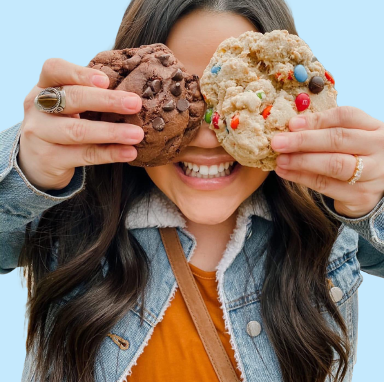 Playful image of woman with cookies in front of her eyes